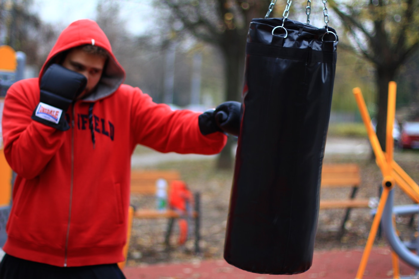 Un boxeur travaille le sac, seul, dans une salle sombre